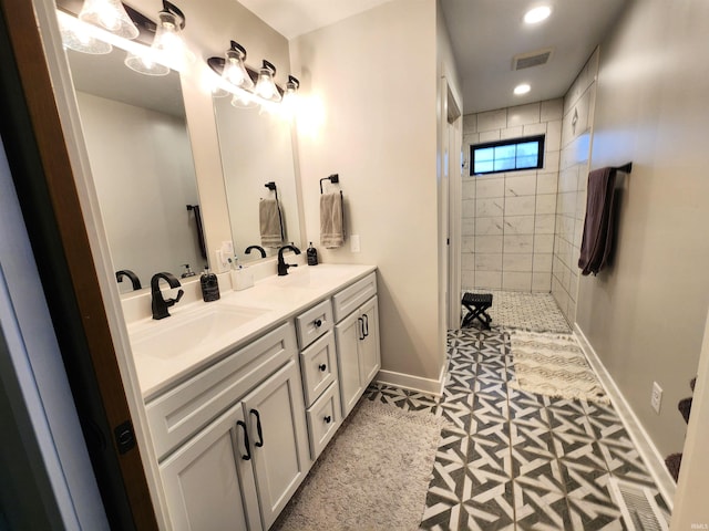 bathroom with tile patterned floors, vanity, and tiled shower