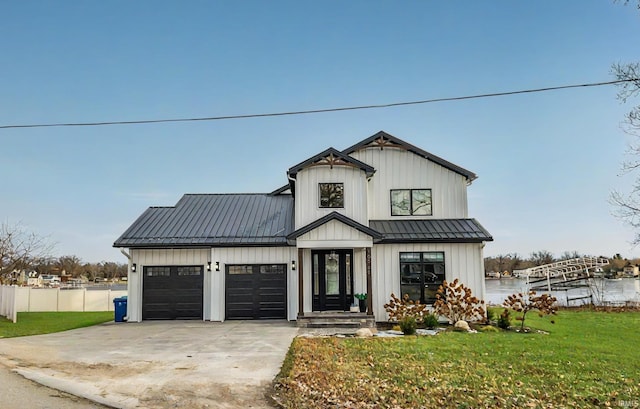 modern farmhouse style home featuring a water view, a garage, and a front lawn