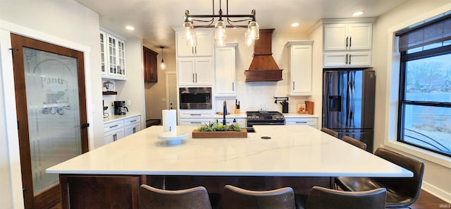 kitchen featuring white cabinetry, a kitchen breakfast bar, refrigerator with ice dispenser, black gas stove, and pendant lighting