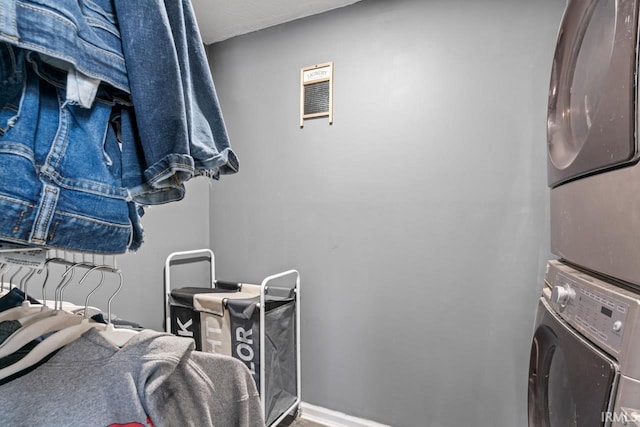 washroom featuring stacked washer / drying machine