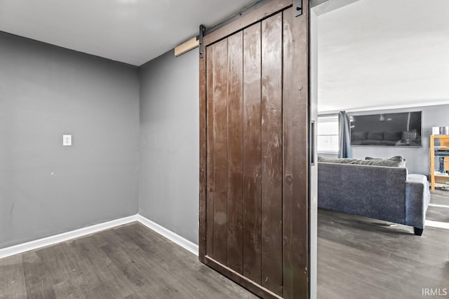 interior space featuring a barn door and dark hardwood / wood-style floors