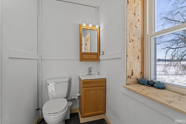 bathroom with vanity, a healthy amount of sunlight, and toilet