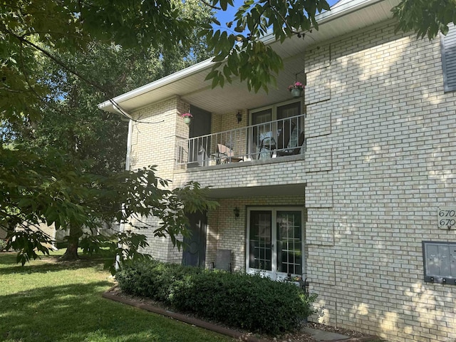 view of home's exterior featuring a yard and a balcony