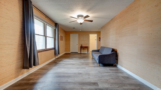 unfurnished room with hardwood / wood-style floors, a textured ceiling, and ceiling fan