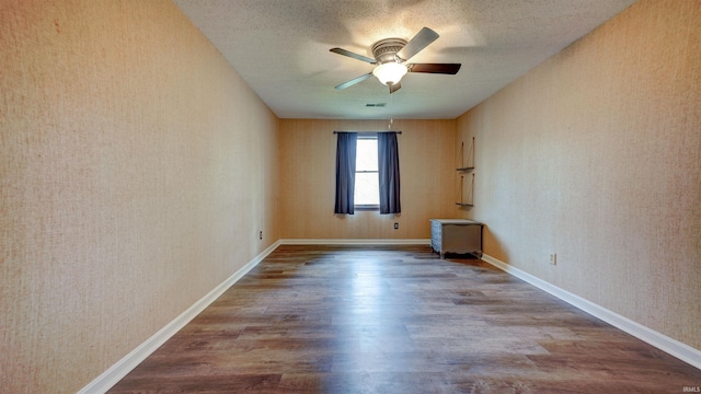 unfurnished room with hardwood / wood-style flooring, ceiling fan, and a textured ceiling