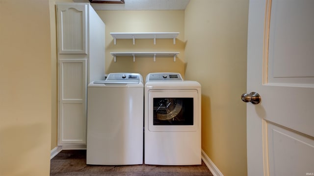 washroom featuring washing machine and clothes dryer, cabinets, and a textured ceiling