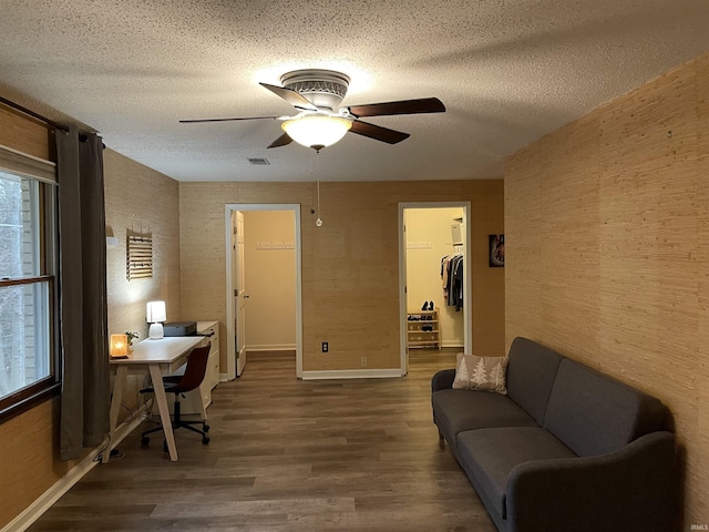 office featuring ceiling fan, dark wood-type flooring, and a textured ceiling