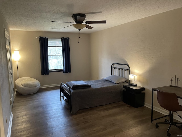 bedroom with a textured ceiling, ceiling fan, and dark wood-type flooring