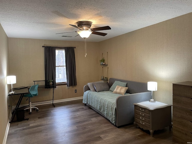 bedroom with a textured ceiling, ceiling fan, and dark wood-type flooring