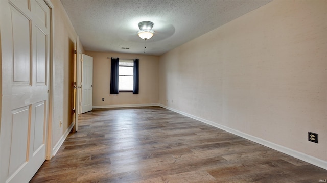 spare room with a textured ceiling, light hardwood / wood-style flooring, and ceiling fan