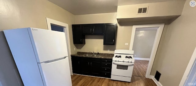 kitchen with white appliances, sink, and dark wood-type flooring