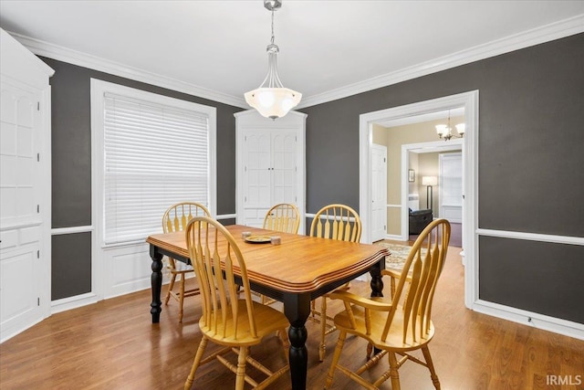 dining space featuring hardwood / wood-style flooring, ornamental molding, and a chandelier