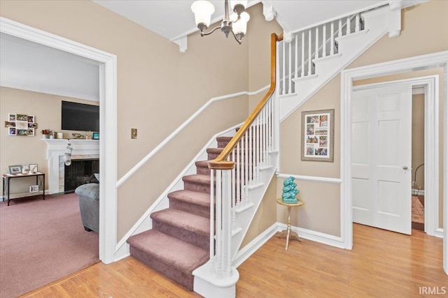 stairs featuring an inviting chandelier and hardwood / wood-style flooring