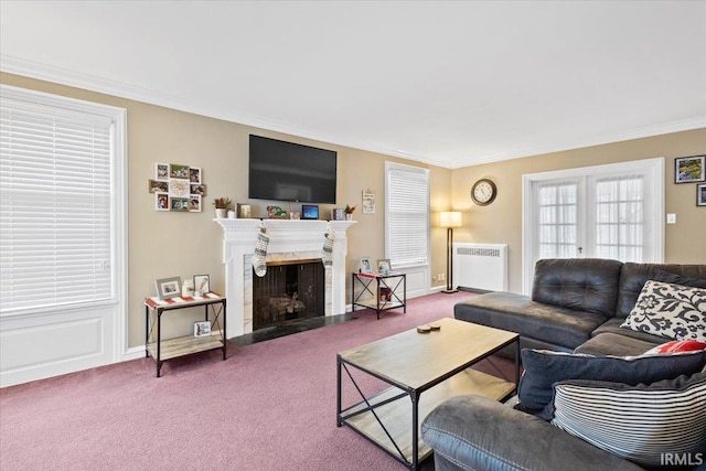 carpeted living room with radiator, a fireplace, french doors, and ornamental molding