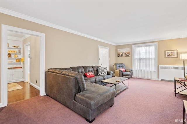 living room featuring carpet flooring, built in shelves, radiator, and ornamental molding