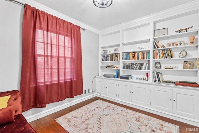 living area featuring crown molding and dark wood-type flooring