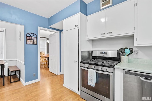 kitchen with white cabinets, stainless steel appliances, and light wood-type flooring