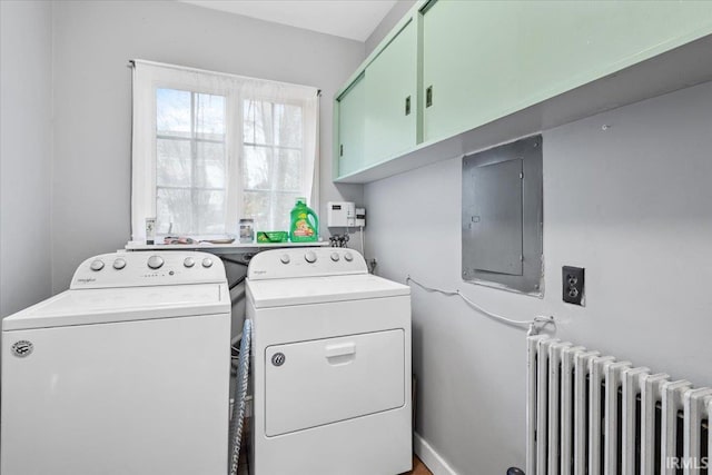 laundry area featuring electric panel, radiator heating unit, cabinets, and independent washer and dryer