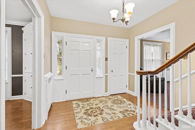 entryway featuring plenty of natural light, light wood-type flooring, and an inviting chandelier