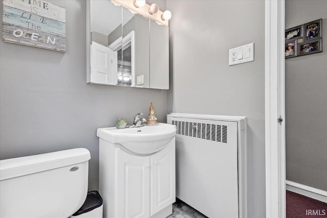 bathroom with radiator, vanity, and toilet