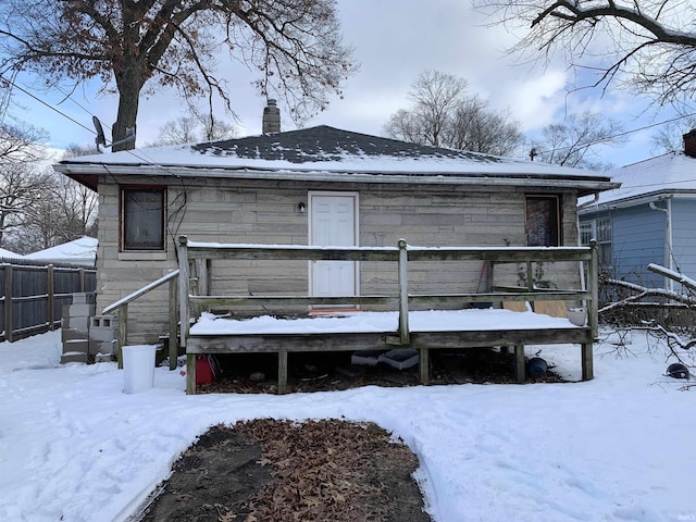 snow covered house with a deck