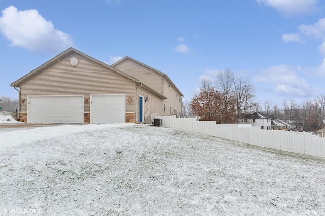 view of property exterior with a garage and central air condition unit