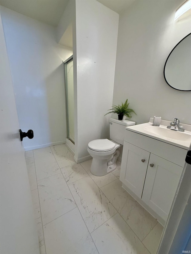 bathroom with vanity, a shower with door, and toilet