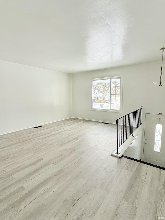 unfurnished living room featuring plenty of natural light and light hardwood / wood-style flooring