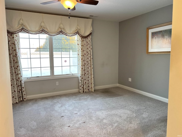 carpeted spare room featuring ceiling fan and a healthy amount of sunlight