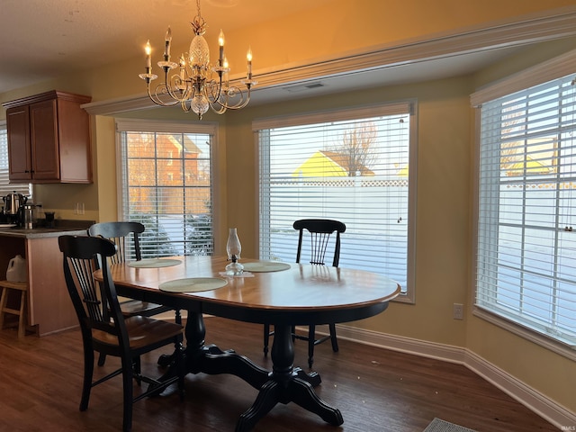 dining space featuring dark hardwood / wood-style floors and a chandelier