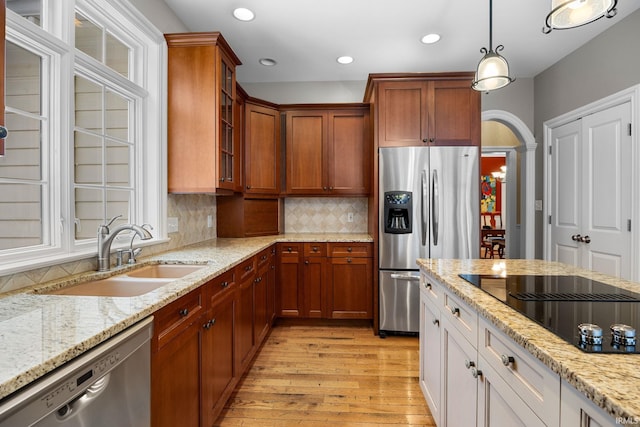 kitchen featuring light stone countertops, appliances with stainless steel finishes, white cabinetry, and sink