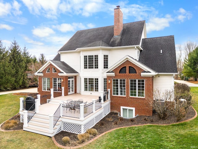 rear view of property with a lawn and a wooden deck