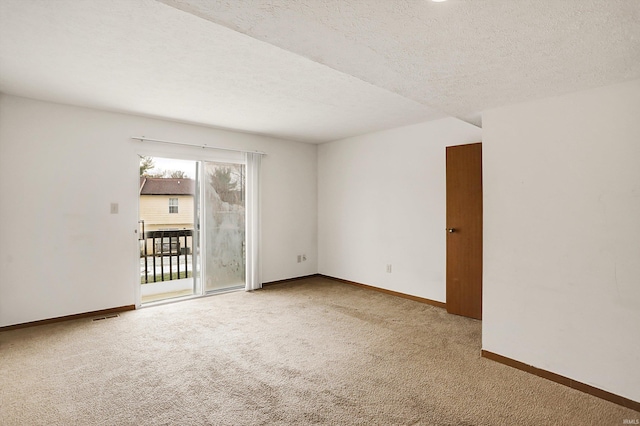 carpeted empty room with a textured ceiling