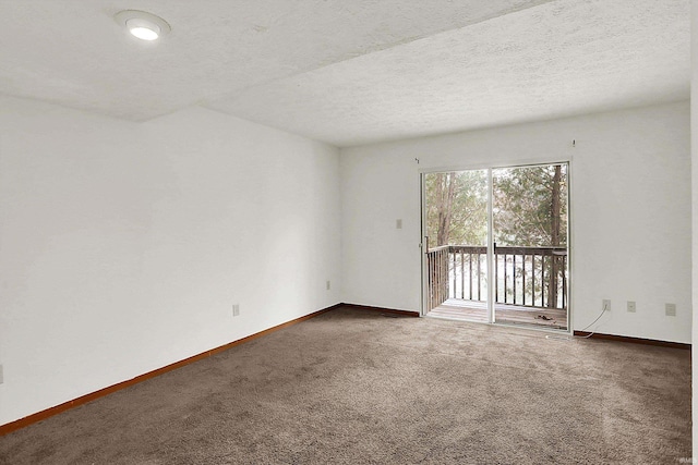 empty room with a textured ceiling and dark colored carpet