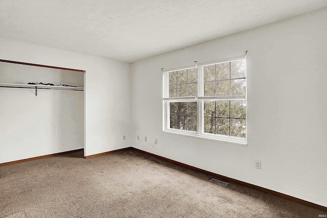 unfurnished bedroom featuring a closet, carpet floors, and a textured ceiling