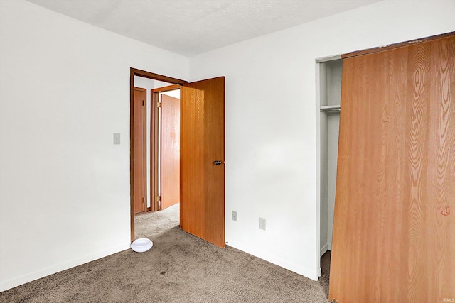 unfurnished bedroom featuring carpet flooring and a closet