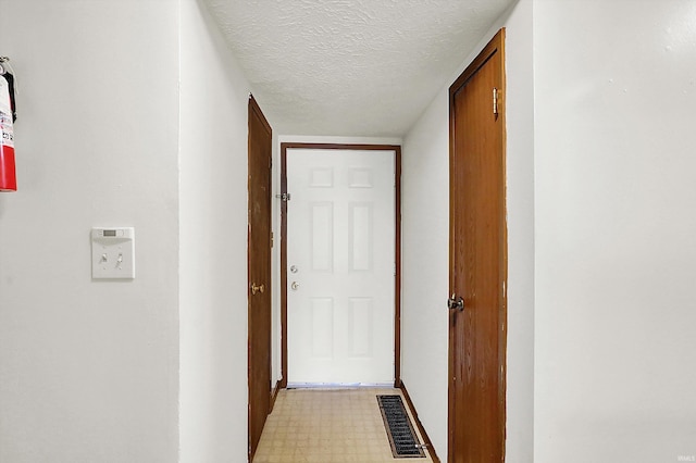 hall featuring a textured ceiling