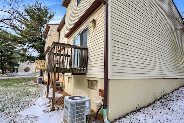 view of snowy exterior featuring central AC and a wooden deck