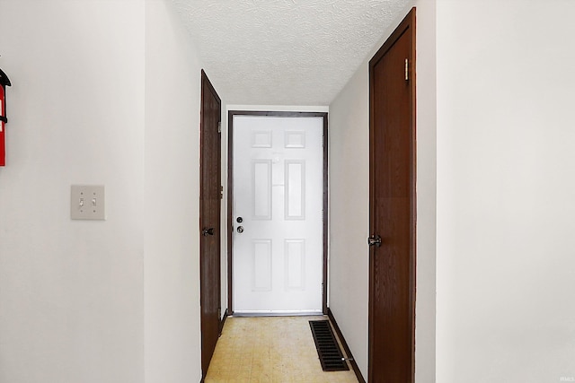 hallway with a textured ceiling