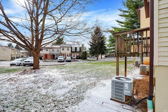 yard layered in snow featuring central air condition unit