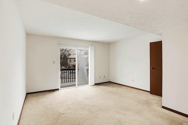 carpeted spare room featuring a textured ceiling