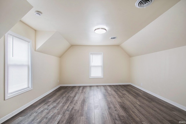 bonus room with dark wood-type flooring and vaulted ceiling