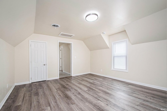 bonus room featuring wood-type flooring and vaulted ceiling