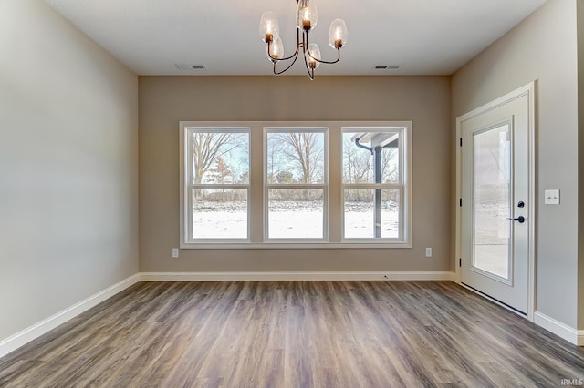 unfurnished dining area with hardwood / wood-style flooring and an inviting chandelier