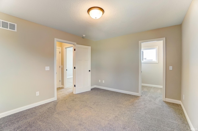 spare room featuring light colored carpet