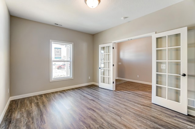 unfurnished room featuring french doors and hardwood / wood-style floors