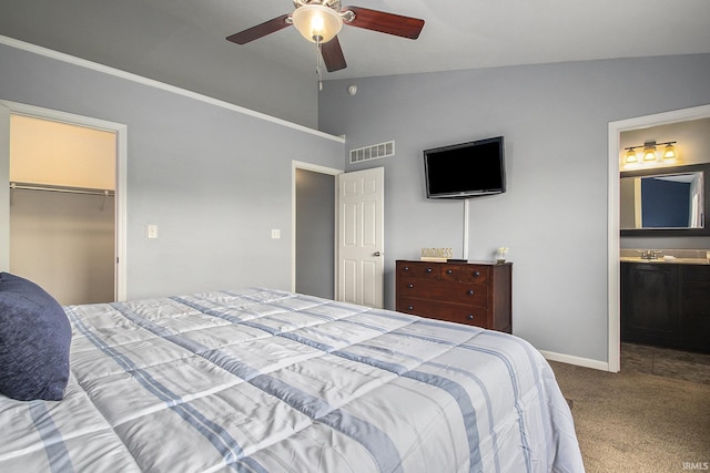 carpeted bedroom featuring ensuite bathroom, vaulted ceiling, ceiling fan, a spacious closet, and a closet