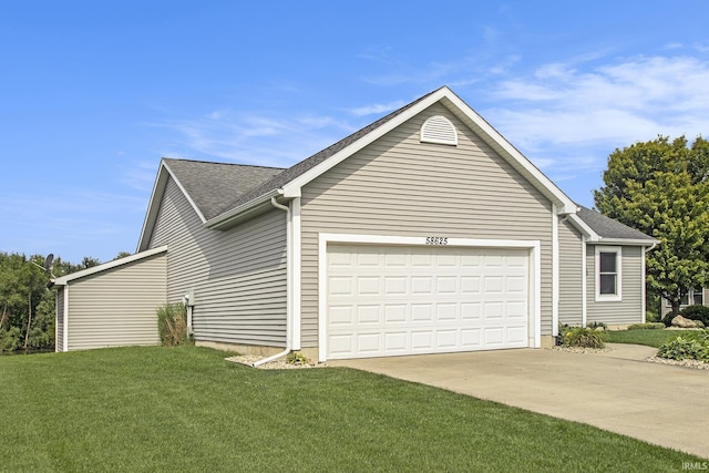 view of home's exterior with a garage and a lawn