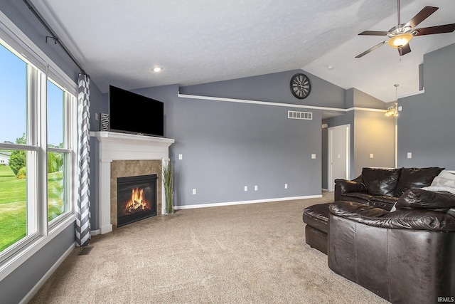 living room with vaulted ceiling, a fireplace, carpet floors, and ceiling fan with notable chandelier