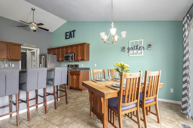 dining area with sink, a textured ceiling, vaulted ceiling, light tile patterned floors, and ceiling fan with notable chandelier